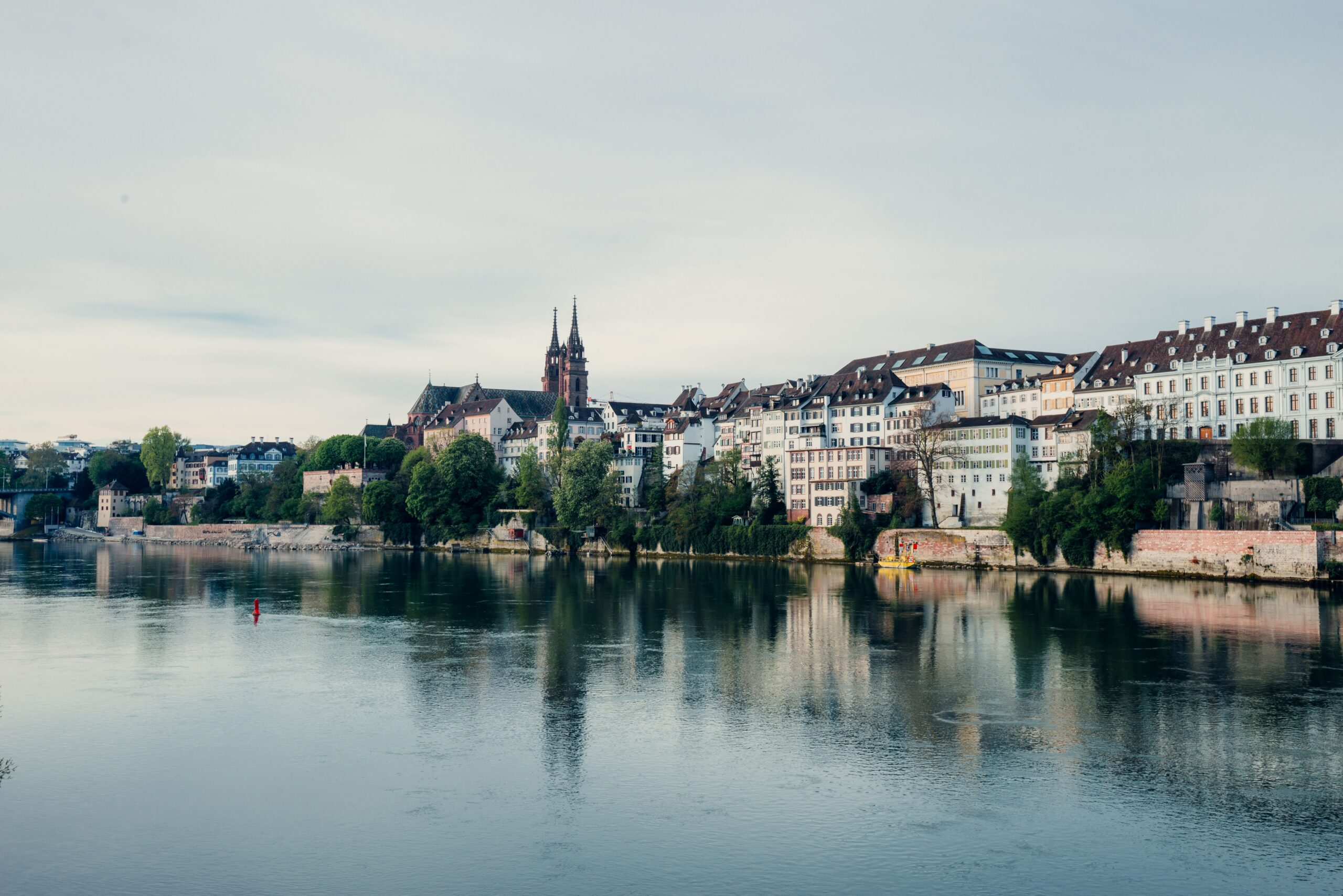 Charming riverfront view of Basel, Switzerland, showcasing historic architecture along the Rhine River.